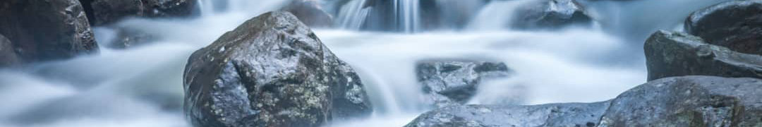 Flowing Water Among the Rocks Flowing water winding through moss-covered rocks