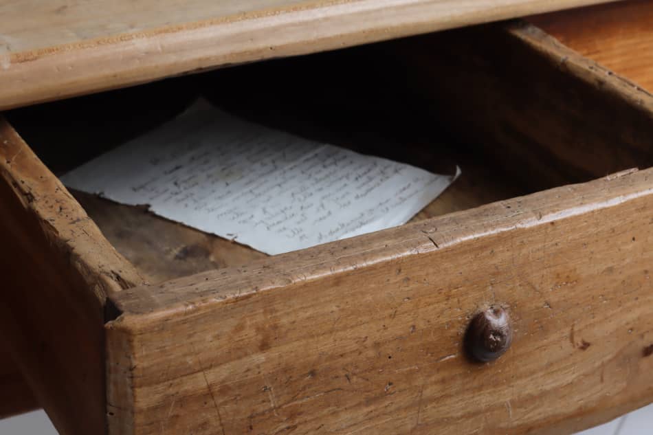 Old handwritten pages preserved inside a wooden drawer