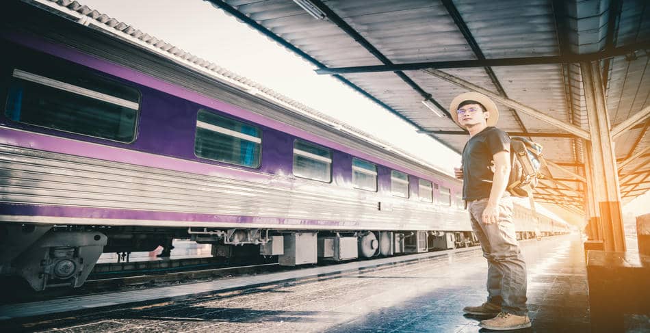 Person standing on a quiet train platform in warm early morning light
