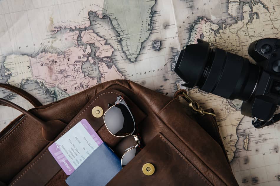 Open leather travel bag resting on a map with belongings packed inside